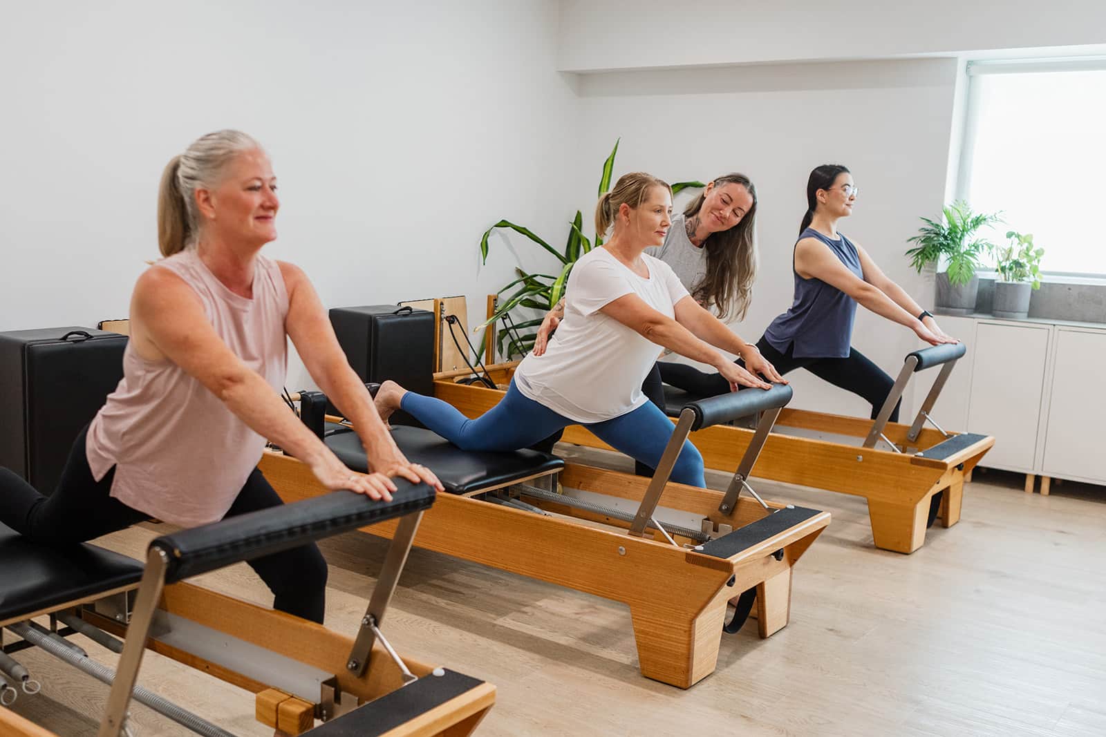Beginners group reformer Pilates class doing a supported lunge stretch at Pilates on Collingwood Street, Albion Brisbane